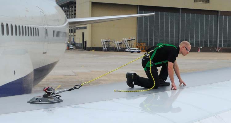 Safe work or access over aircraft - Worker working at heights following safety procedure